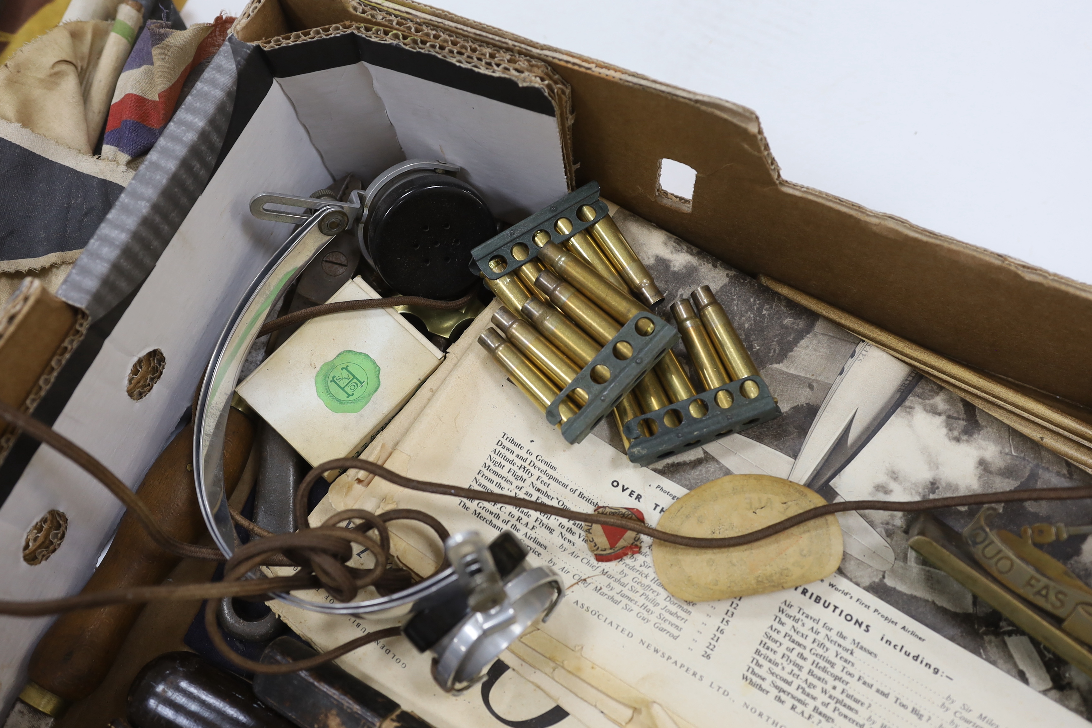 A collection of Militaria and other items, including a Royal Artillery brass cased timepiece, headphones, crepe paper bunting contained in a card Worthington’s IPA beer bottle, etc.